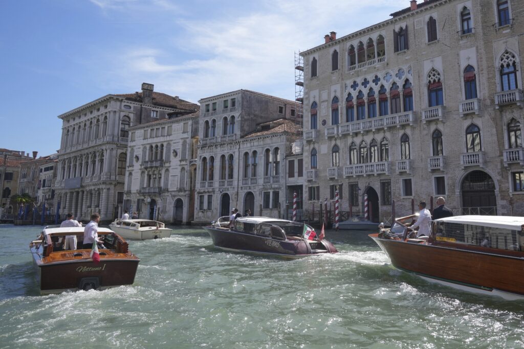 A boat, center, carrying Lauren Sanchez, leaves a hotel ahead of the anticipated wedding celebrations with Jeff Bezos, in Venice, Italy, Friday, June 27, 2025.