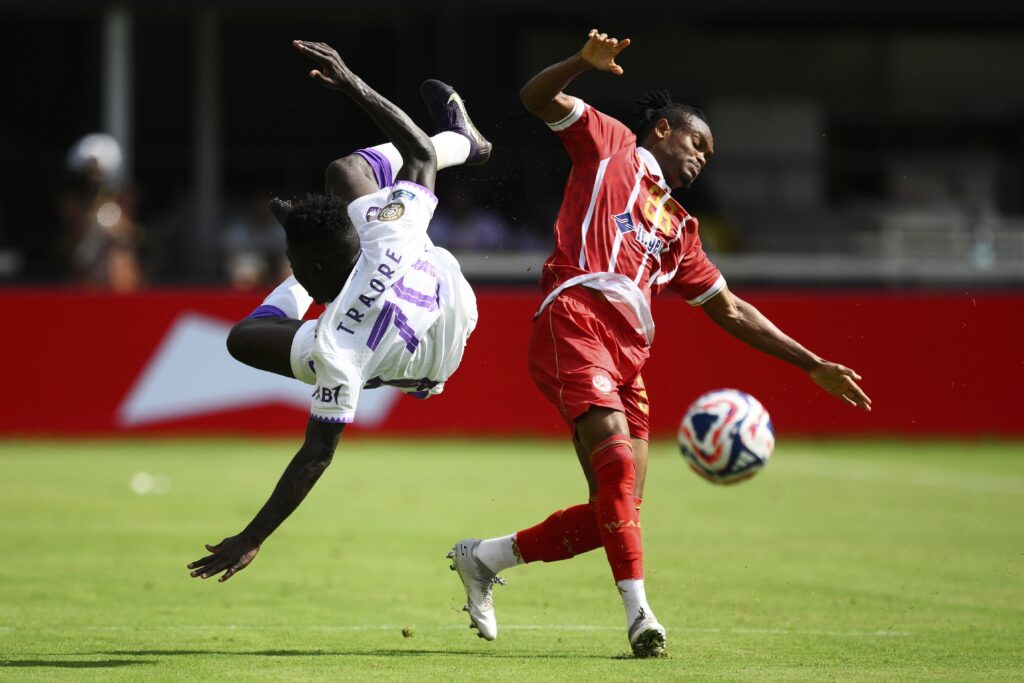 Al Ain's Abdoul Karim Traore, left, falls after colliding with Wydad AC's Selemani Mwalimu during the Club World Cup Group G soccer match between Wydad AC and Al Ain FC in Washington, Thursday, June 26, 2025.