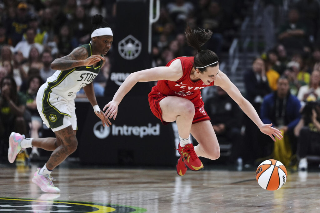 Seattle Storm guard Erica Wheeler looks on as Indiana Fever guard Caitlin Clark (22) falls while reaching for the ball during the second half of a WNBA basketball game Tuesday, June 24, 2025, in Seattle.