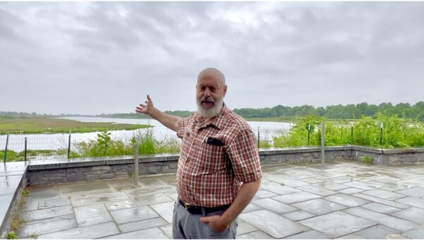 Retired NYC Parks Chief Naturalist Mike Feller stands at the back courtyard of the Salt Marsh Nature Center and points out towards the east side of Gerritsen Creek. Photo by Loretta Chin
