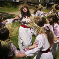 Girls wearing crowns made of flowers dance during an event inspired by pre-Christian traditions, in which fairies, called in Romanian "Sanziene," come to earth around the summer solstice bringing fertility to land and beings, at the Dimitrie Gusti Village Museum in Bucharest, Romania, Tuesday, June 24, 2025.