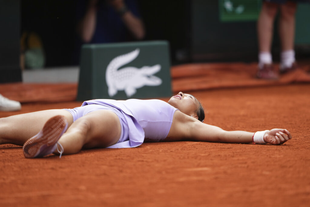 China's Zheng Qinwen lies on the court as she celebrates beating Russia's Liudmila Samsonova during their fourth round match of the French Tennis Open, at the Roland-Garros stadium, in Paris, Sunday, June 1 2025.