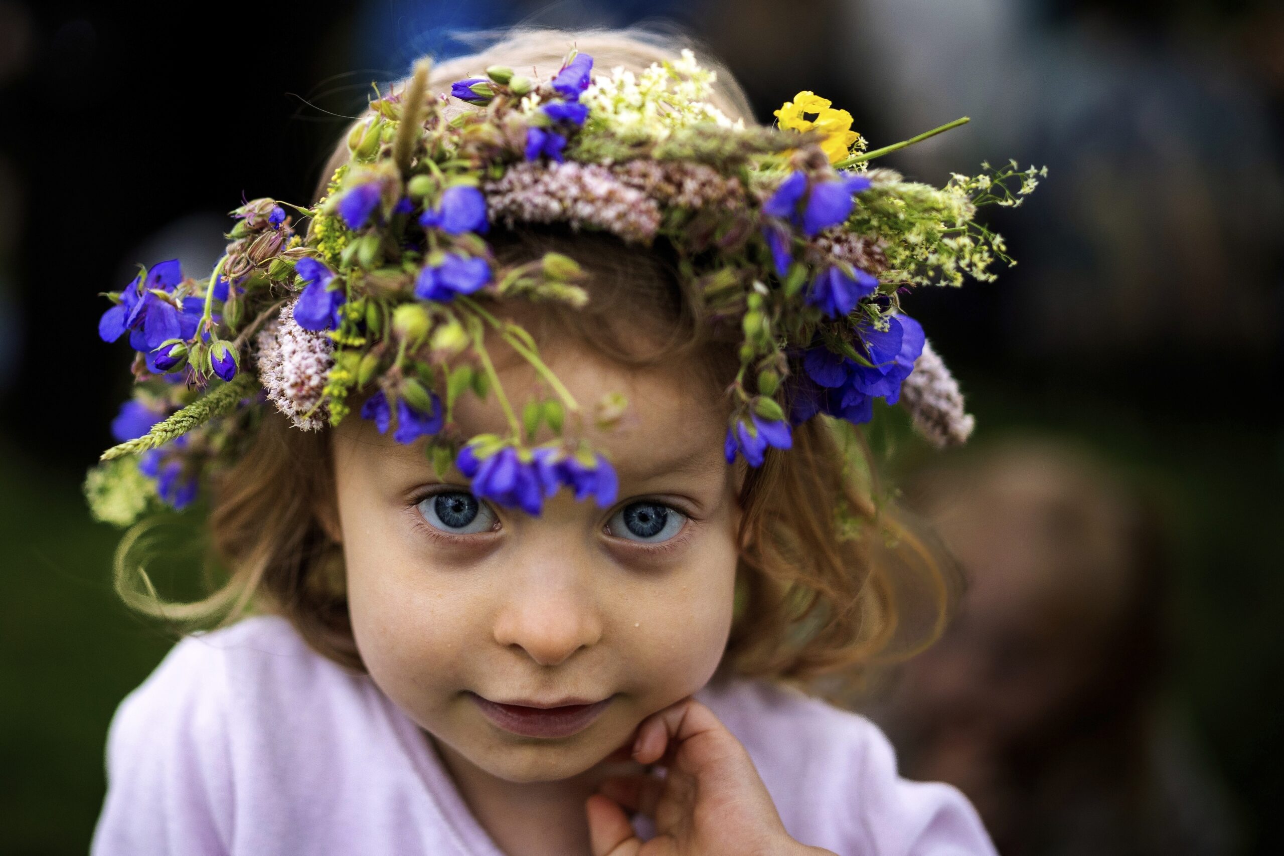A girl wearing a crown made of flowers takes part in the Saint John's Day and Summer Solstice celebration in the small town of Kernave, some 35km (22 miles) northwest of the capital, Vilnius, Lithuania, Monday, June 23, 2025.