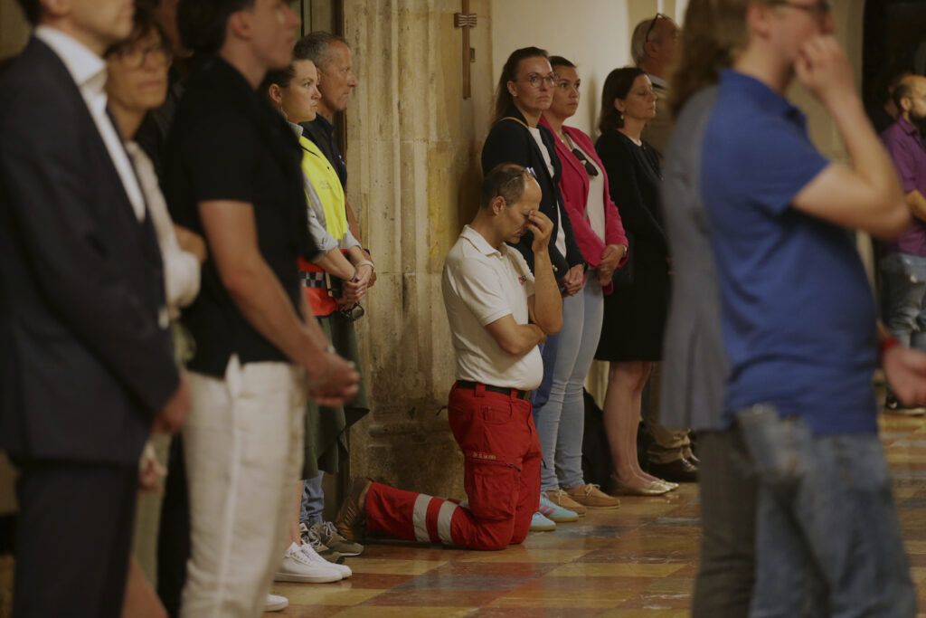 A member of rescue services knees on the floor and pray during a memorial service, following a shooting at a school, at the cathedral in Graz, Austria, Tuesday, June 10, 2025.