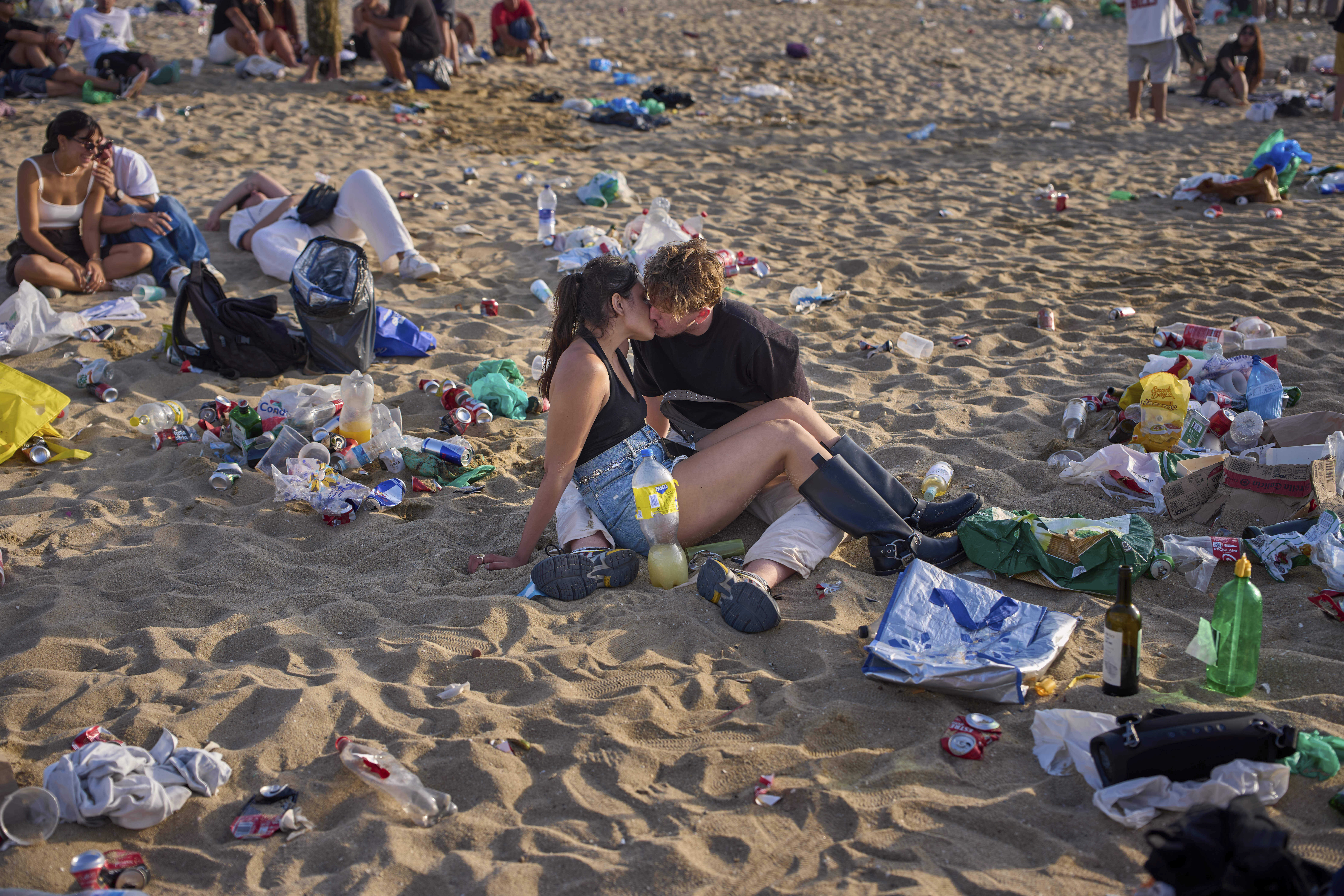 A couple kiss as they celebrate the night of San Juan on the beach, watching the sunrise that coincides with the summer solstice, marking the arrival of the summer season in Barcelona, Spain, Tuesday, June 24, 2025.