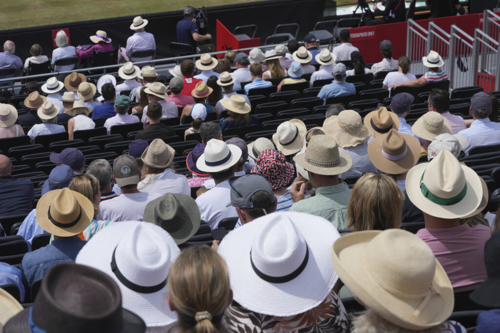 Spectators wear hats to keep cool in the stands during the match of the Queen's Club Championships tennis tournament in London, Friday, June 20, 2025.