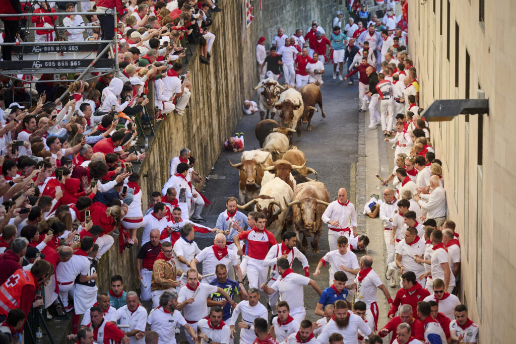 Revelers run with bulls from Alvaro Nunez ranch during the third day of the running of the bulls at the San Fermín fiestas in Pamplona, Spain, Wednesday, July 9, 2025.