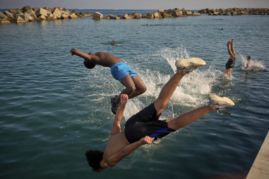 Men jump into the water on a hot day in Barcelona, Spain, Tuesday, July 1, 2025.