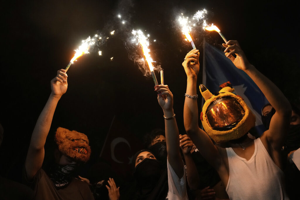 People light flares during a protest called by the main opposition Republican People's Party or (CHP), outside the City Hall in Istanbul, Turkey, Tuesday, July 1, 2025.