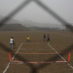 Tennis coach Delfin Barrial, left, teaches children how to hold a racket during a class in the Jicamarca neighborhood on the outskirts of Lima, Peru, Sunday, July 6, 2025.