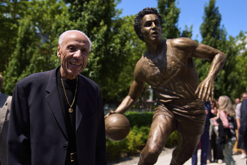 Former NBA basketball player and coach Lenny Wilkens poses for a photo with his statue after its unveiling outside of Climate Pledge Arena, Saturday, June 28, 2025, in Seattle. AP Photo/Lindsey Wasson