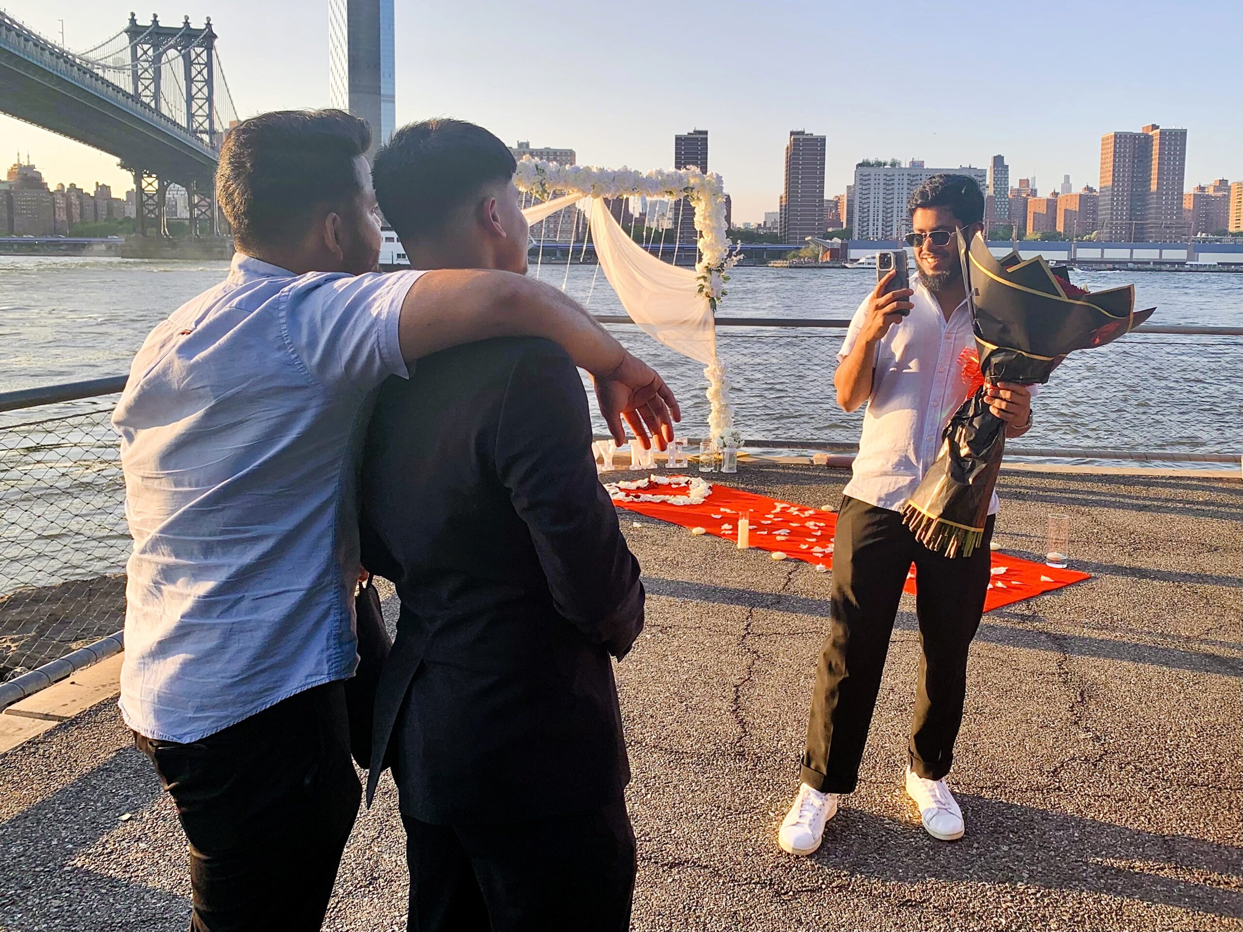 Friends take photos of a hopeful young man before he proposes. Will she say yes? Brooklyn Eagle photo by Mary Frost