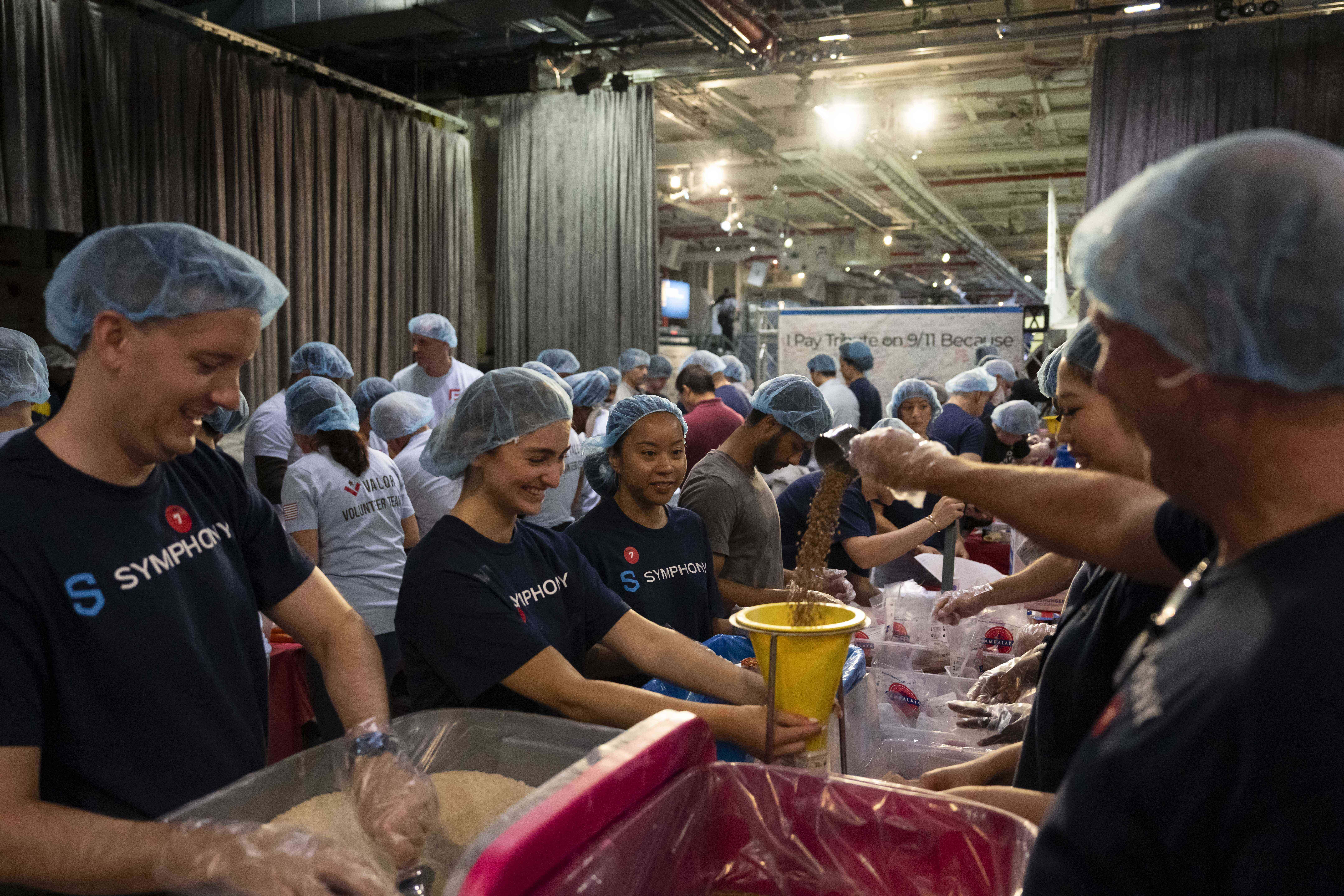Volunteers work during the "NYC Meal Pack For 9/11 Day" at the Intrepid Museum, Wednesday, Sep. 10, 2025, in New York. AP Photo/Yuki Iwamura