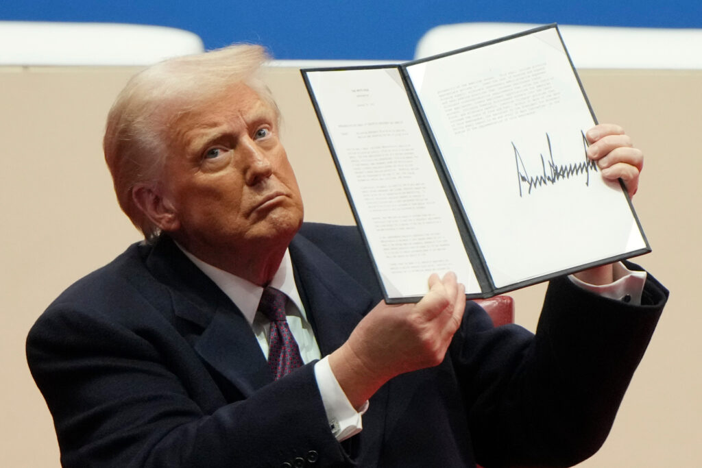 President Donald Trump holds up an executive order after signing it at an indoor Presidential Inauguration parade event in Washington, Jan. 20, 2025. Photo: Matt Rourke/AP