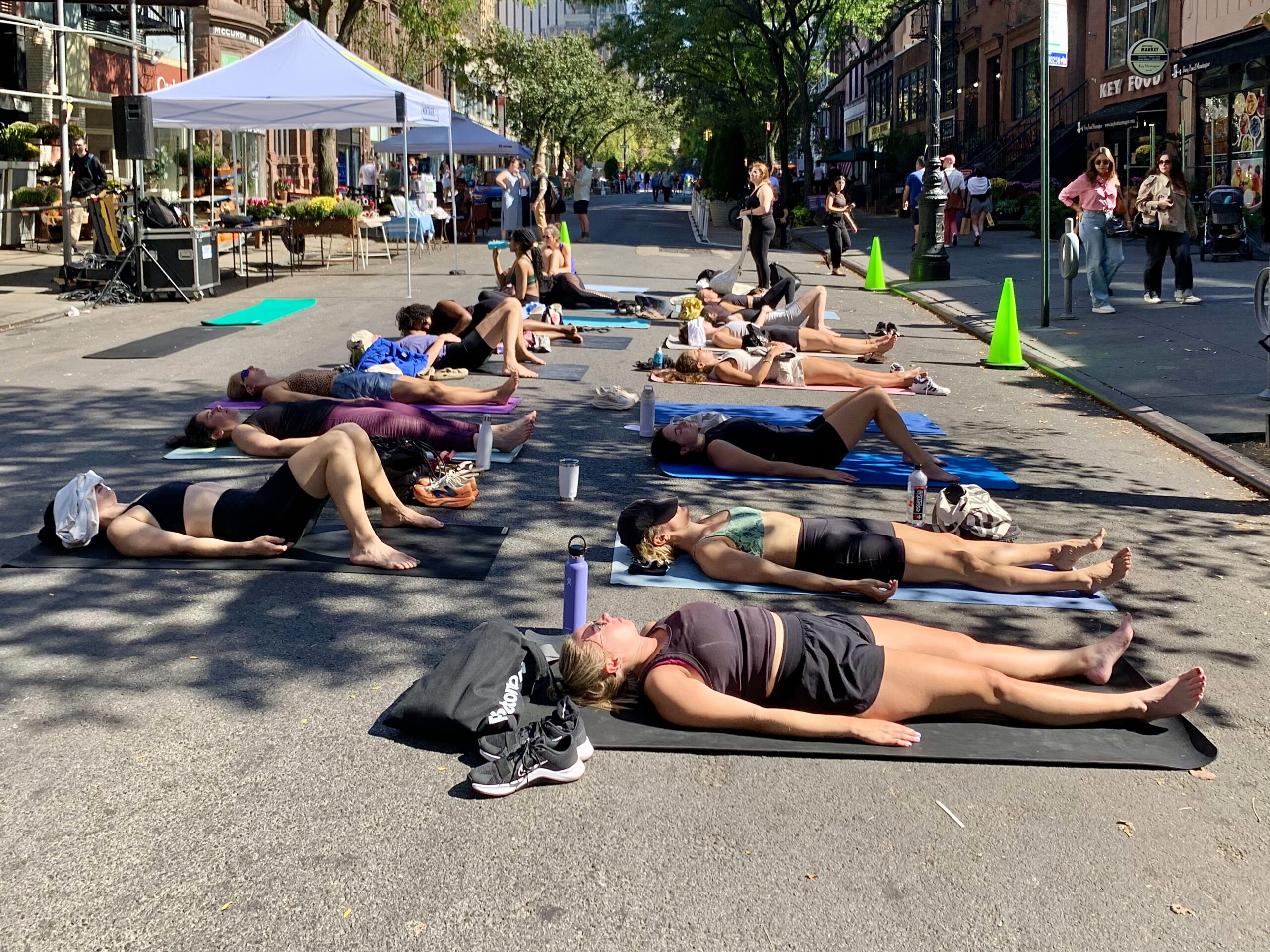 Yoga enthusiasts stretched out on their exercise pads right in the street under the eye of an instructor from GTHR Yoga, as a loudspeaker intoned the cosmic Om sound. Photo: Mary Frost, Brooklyn Eagle