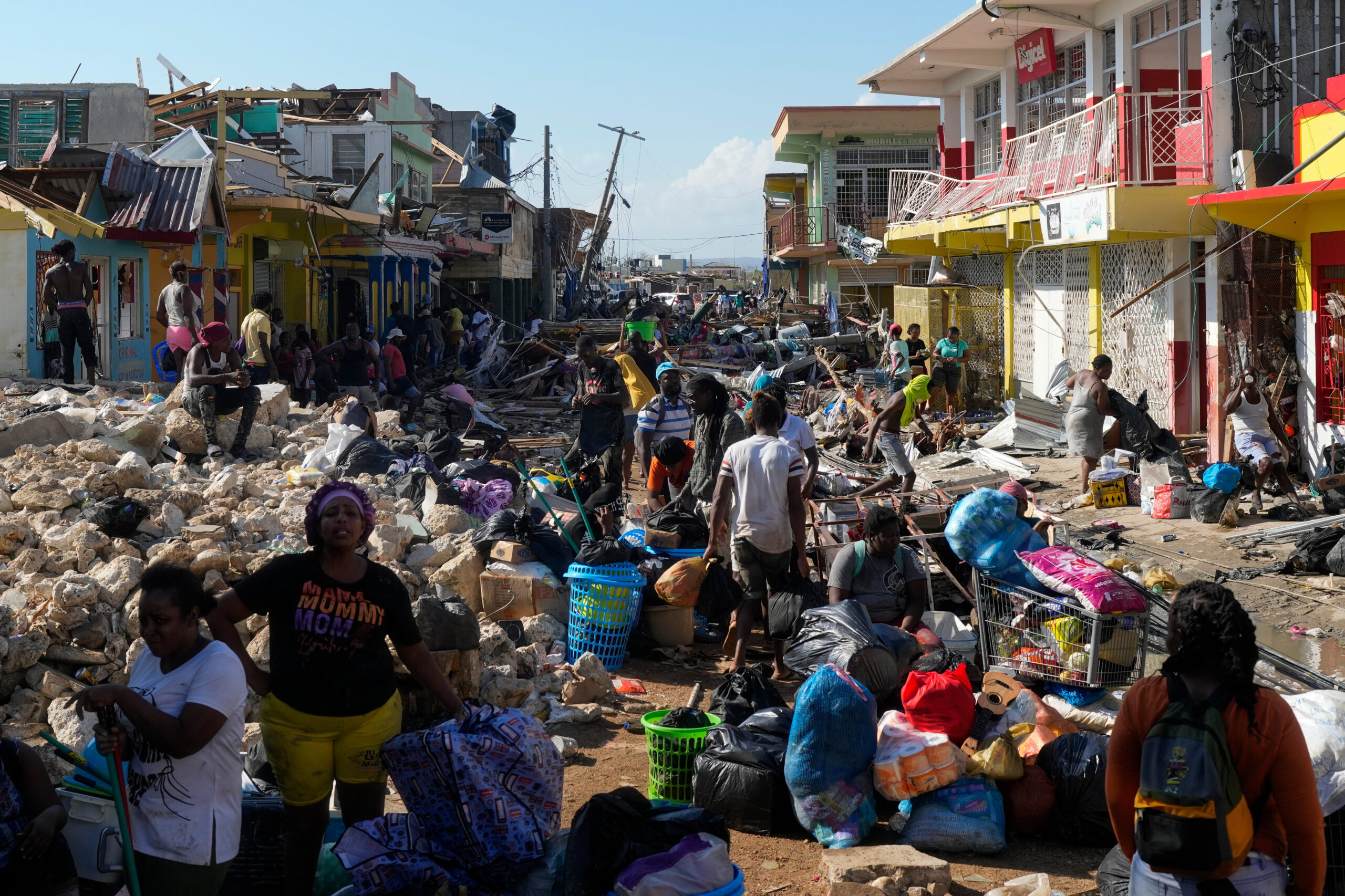Residents gather amid debris in the aftermath of Hurricane Melissa on a street in Black River, Jamaica, Thursday, Oct. 30, 2025. AP Photo/Matias Delacroix