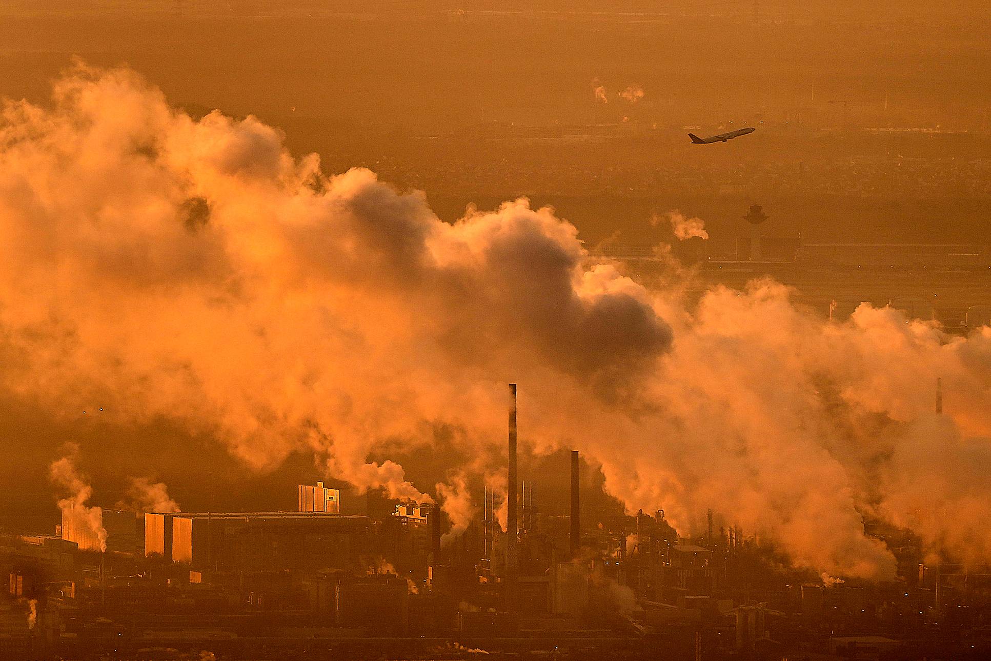 A plane flies behind the smoke from a chemical plant in Frankfurt, Germany, Monday, Dec. 1, 2025. Photo: Michael Probst/AP