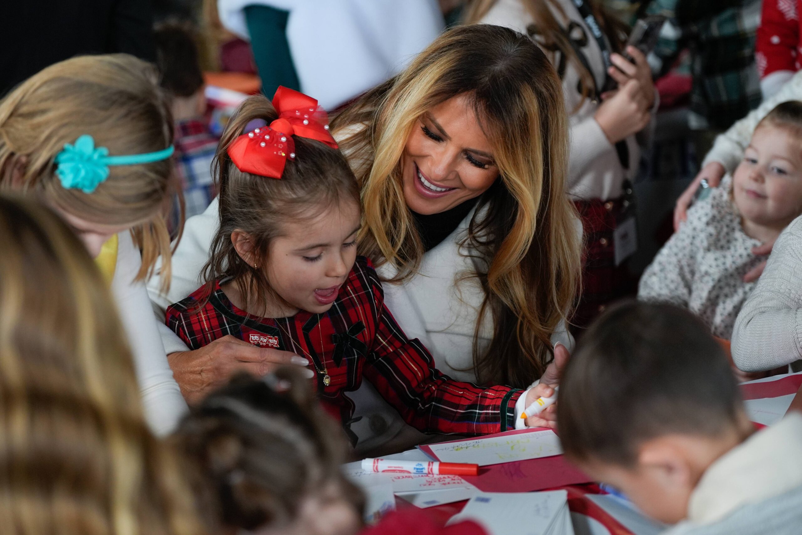 First lady Melania Trump writes holiday cards with kids during a Toys for Tots charity drive event at Marine Corps Base Quantico, Monday, Dec. 8, 2025, in Quantico, Va. Photo: Julia Demaree Nikhinson/AP