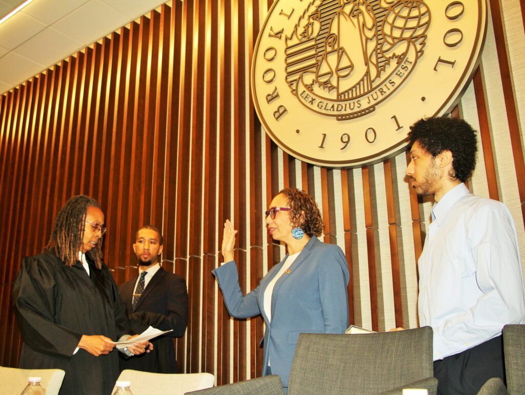 Hon. Juliet Howard being sworn in by Hon. Norma Jennings alongside their sons. Brooklyn Eagle photo by Mario Belluomo