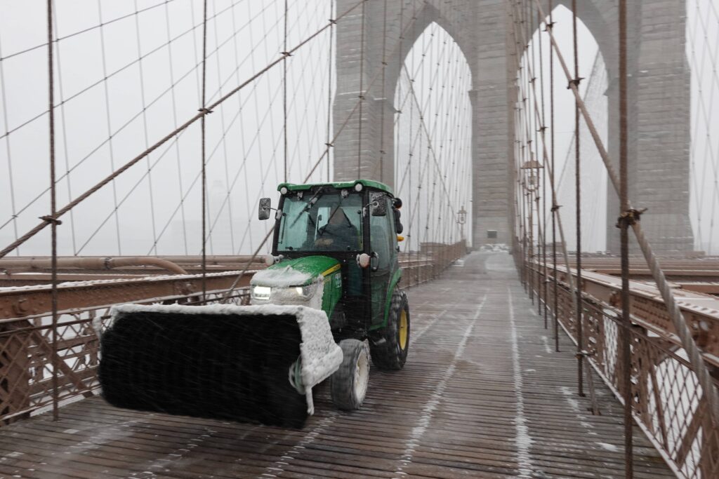 A snow plow goes across the Brooklyn Bridge as it snows on Sunday, Jan. 25, 2026, in New York. Photo: Alyssa Goodman/AP