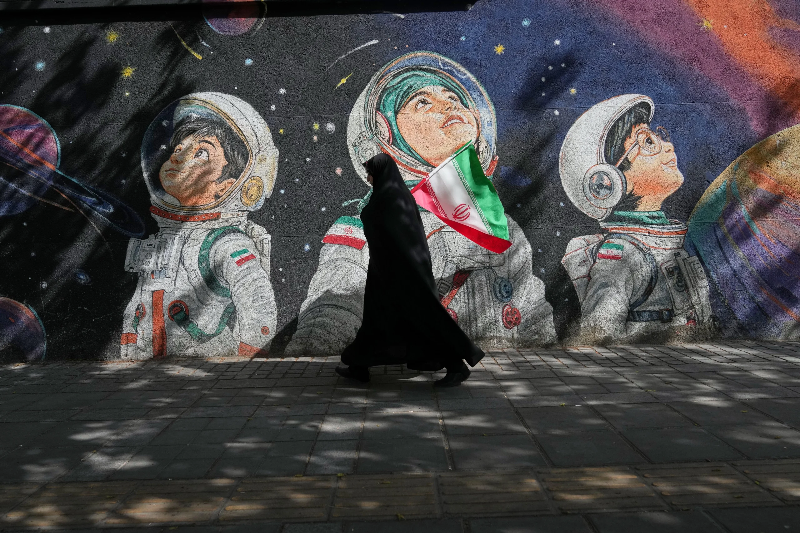 TEHRAN — ‘Ars longa, vita brevis’ — all over the world, murals offer a striking visual surprise: A woman walks past a mural in Tehran, Iran, Wednesday, April 8, 2026. Photo: Francisco Seco/AP