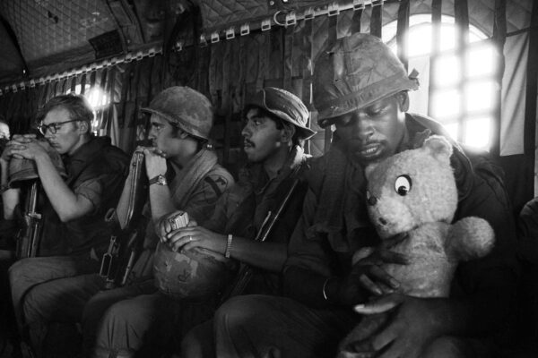 A GI headed into Kontum in the central highlands with a tank-killing unit, cradles his lucky teddy bear during the helicopter ride in Vietnam, June 3, 1972. Photo: Josip Lee/AP, File
