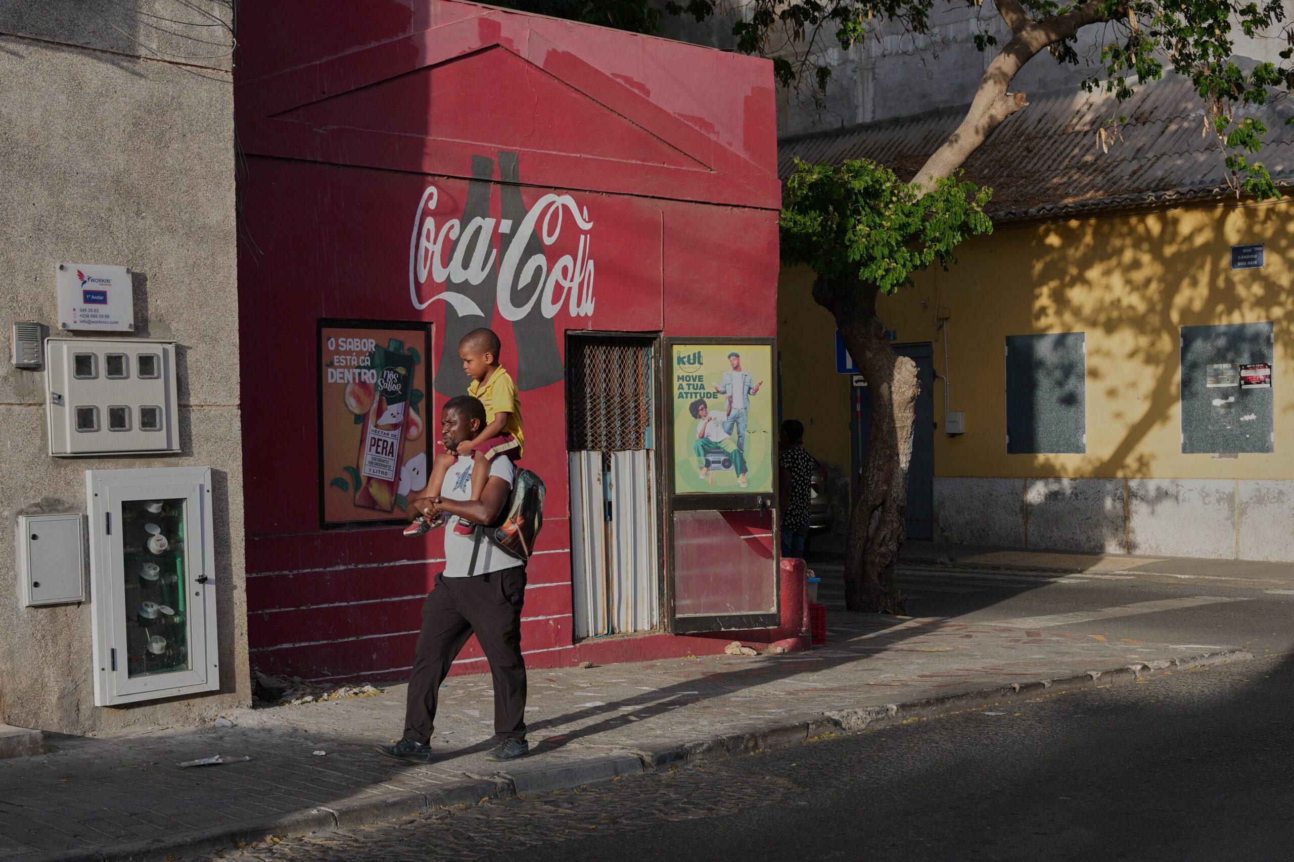 A man carries a boy on his shoulders as he walks along a street in Praia, Cape Verde, Thursday, May 7, 2026. Photo: Misper Apawu/AP