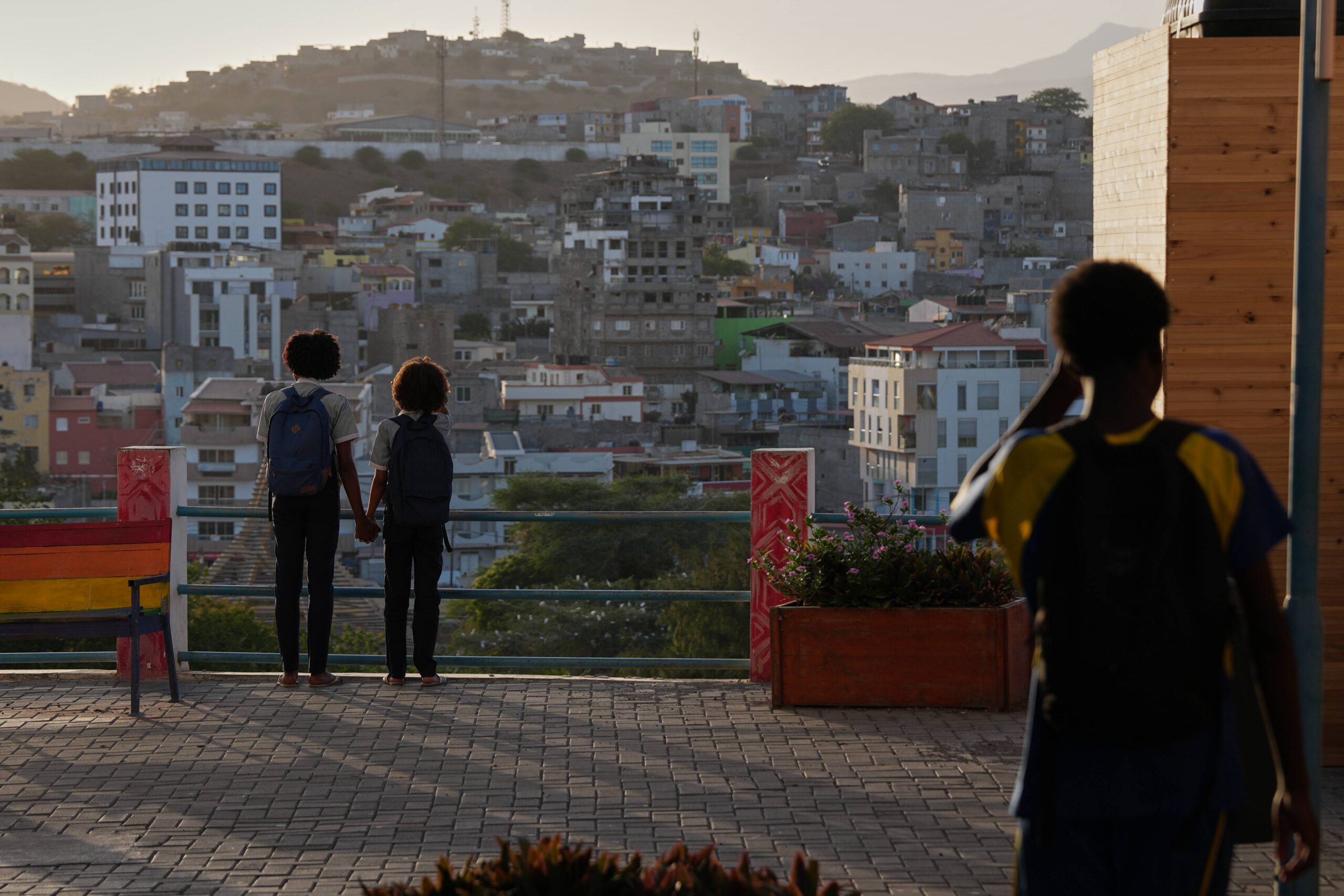 Two schoolgirls hold hands as they look towards the city in Praia, Cape Verde, Thursday, May 7, 2026. Photo: Misper Apawu/AP