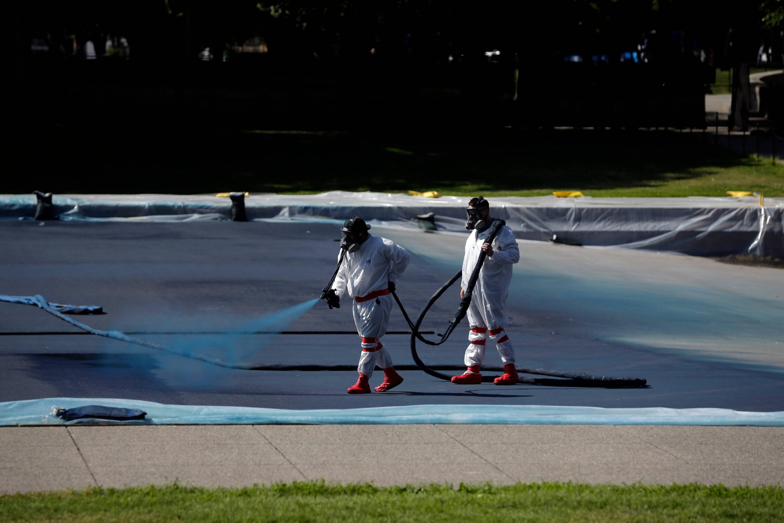 Workers apply a blue protective coating as part of a renovation project to the Lincoln Memorial Reflecting Pool, Friday, May 8, 2026, on the National Mall in Washington. Photo: Rahmat Gul/AP
