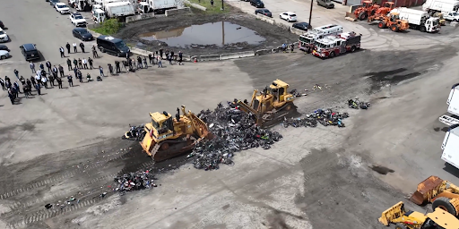 The two bulldozers sit amidst the wreckage of 200 illegal mopeds. Image: NYPD