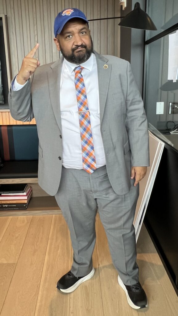 Ahmed Tigani, commissioner of the NYC Department of Buildings, displaying his New York Knicks headgear. Photo: Wayne Daren Schneiderman/Brooklyn Eagle
