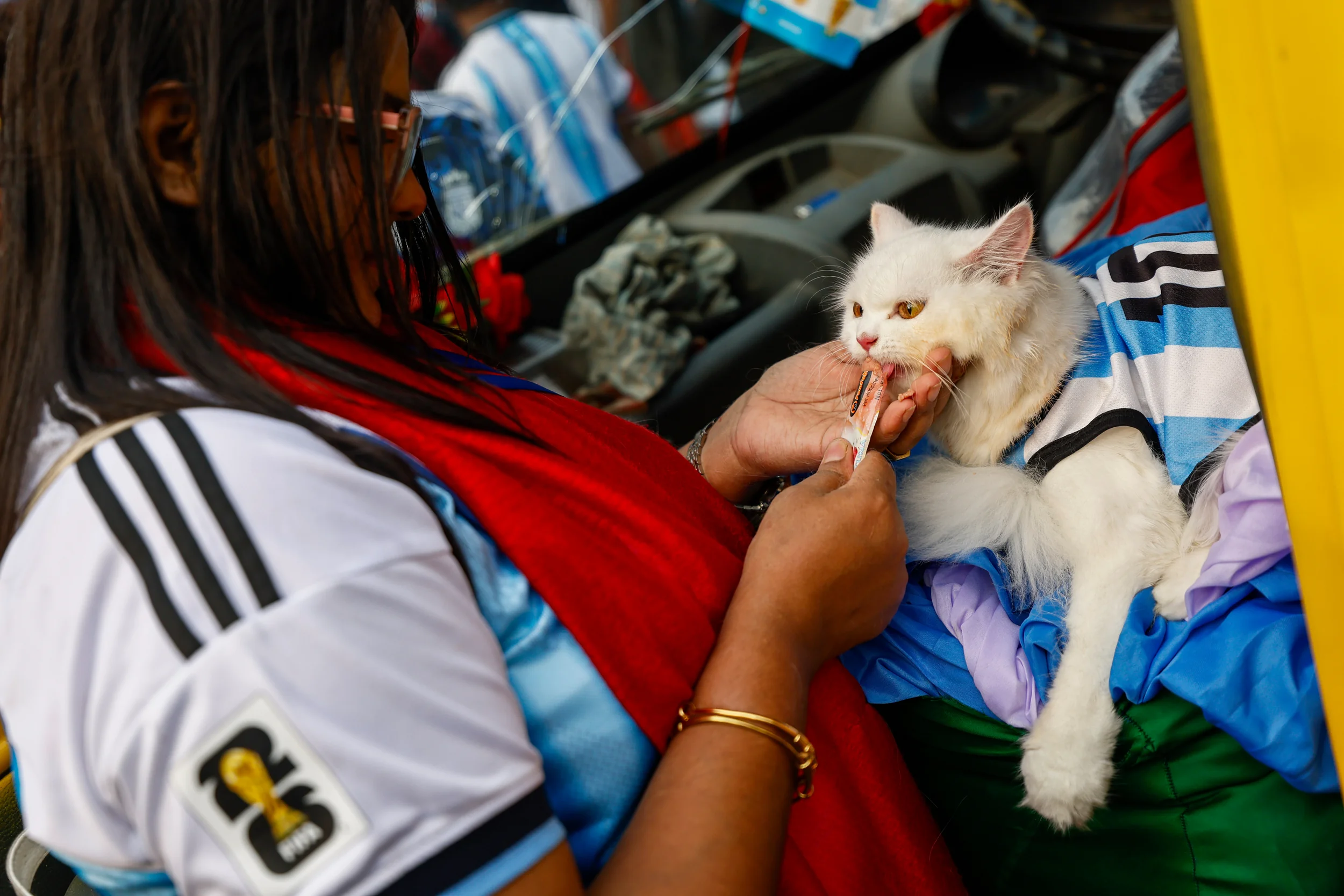 BANGLADESH — ‘C’mon coach, please put me in …’: A Bangladeshi soccer fan wearing an Argentina jersey and feeding a cat, also dressed in a similar jersey, in support of the team competing at the 2026 FIFA World Cup during a rally in Dhaka, Bangladesh, Tuesday, June 16, 2026. Photo: Rajib Dhar/AP