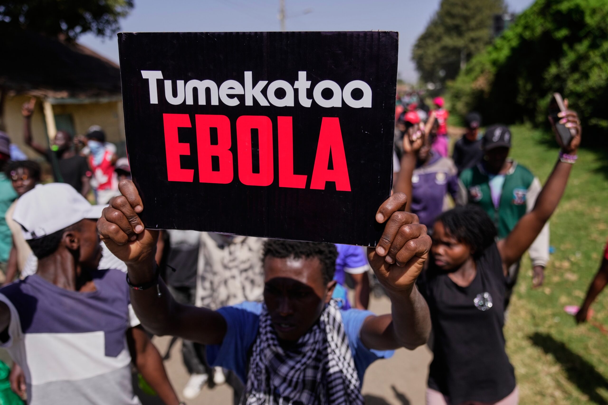 A protester holds a placard reading "Tumekataa Ebola" (We refuse Ebola) during a demonstration against a proposed Ebola quarantine center to be established by the United States at Laikipia Air Base in Nanyuki, Kenya, Tuesday, June 9, 2026. Photo: Brian Inganga/AP