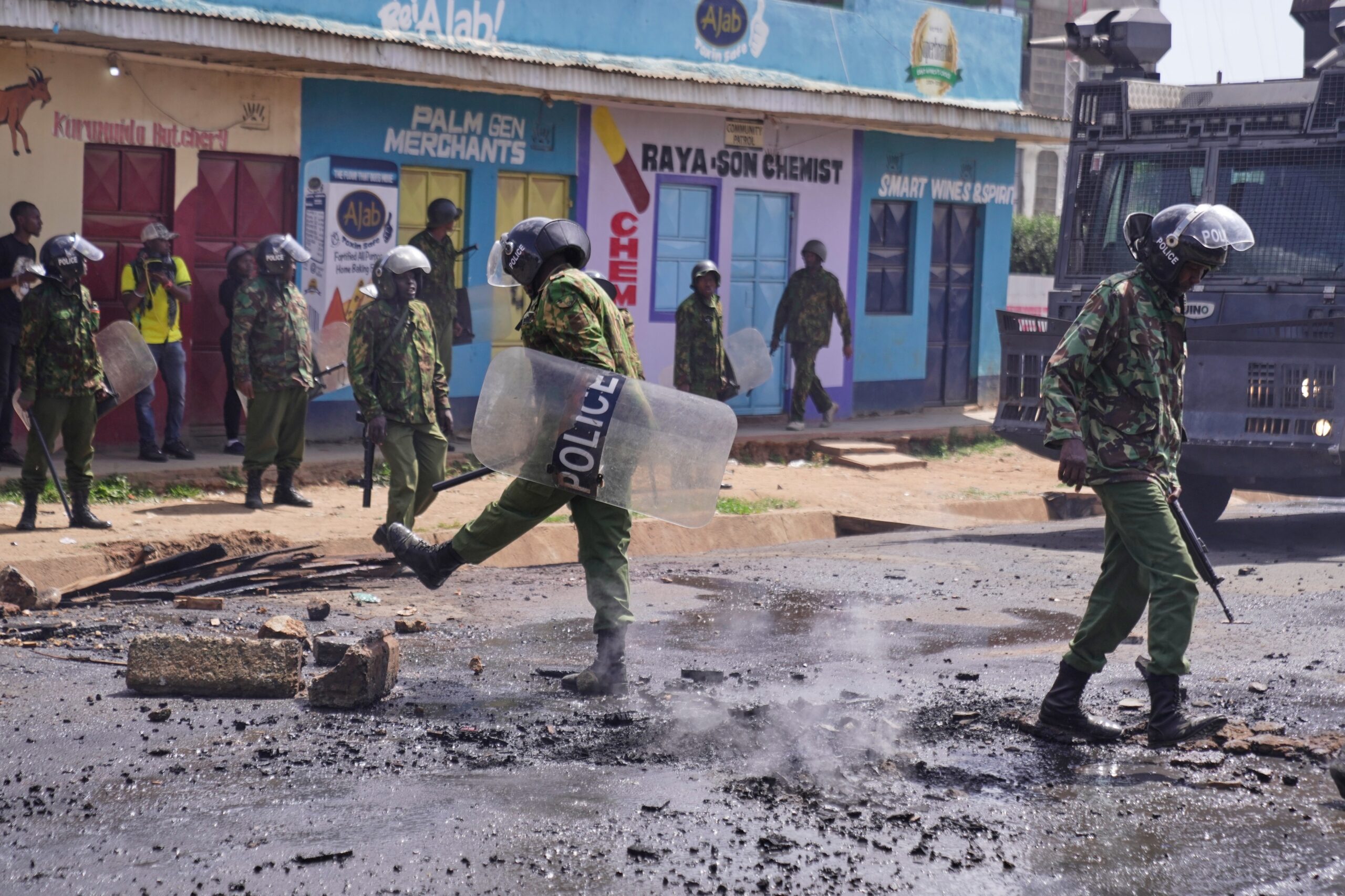 Anti-riot police officers push aside a burning barricade during a demonstration against a proposed Ebola quarantine center to be established by the United States at Laikipia Air Base in Nanyuki, Kenya, Tuesday, June 9, 2026. Photo: Brian Inganga/AP