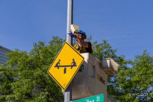 A NYC DOT Traffic Operations worker installing a new activity sensor in Greenpoint. Photo: NYC Dept. of Transportation