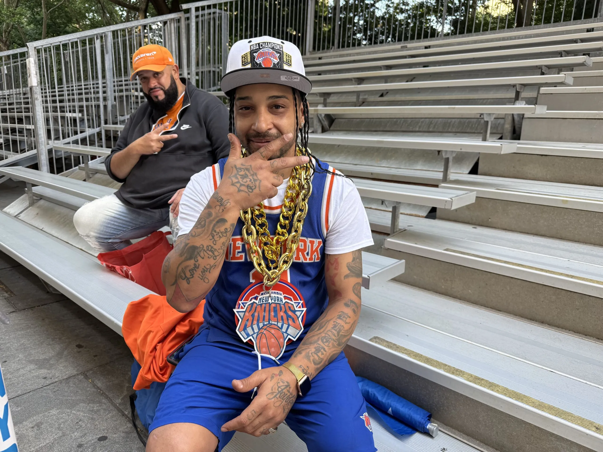 Pedro Alicea, front, says he has been a Knicks fan since he was six years old and will wait overnight on bleachers near City Hall for a view of the parade, June 17, 2026. Credit: Carol Chen/The City Reporter