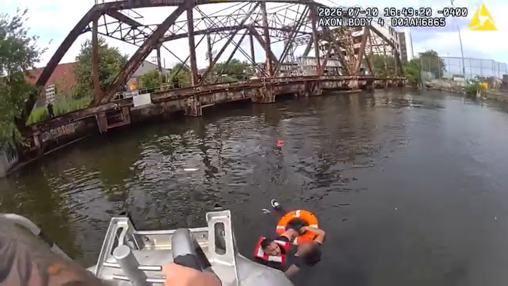 A police officer tows a girl to safety in the Newtown Creek. Photo: NYPD