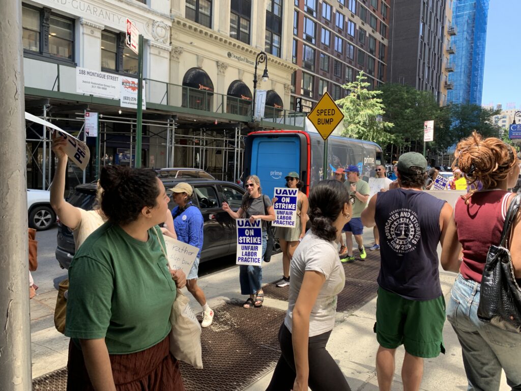 Picketers outside 195 Montague St. held signs and chanted in support of the union’s demands. Photo: Agatha Scaggiante/Brooklyn Eagle
